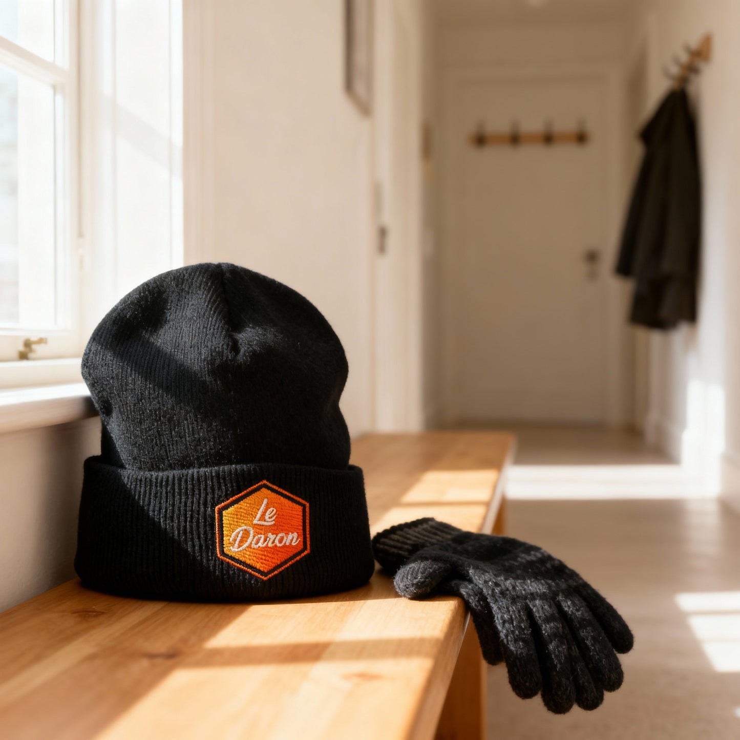Bonnet Le Daron brodé - coloris noir - posé sur une table en bois clair