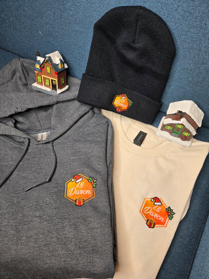 Bundle Édition Limitée Noël du Daron : bonnet, hoodie et t-shirt brodés, présenté ensemble sur fond bleu.