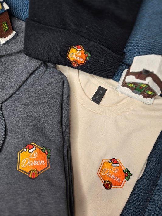 Pack Noël du Daron présenté à plat : bonnet brodé, hoodie gris et t-shirt naturel, édition limitée.